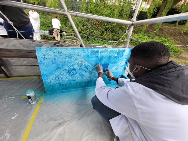 Un élève du lycée Chérioux réalisant une peinture bleue avec des assemblages géométriques